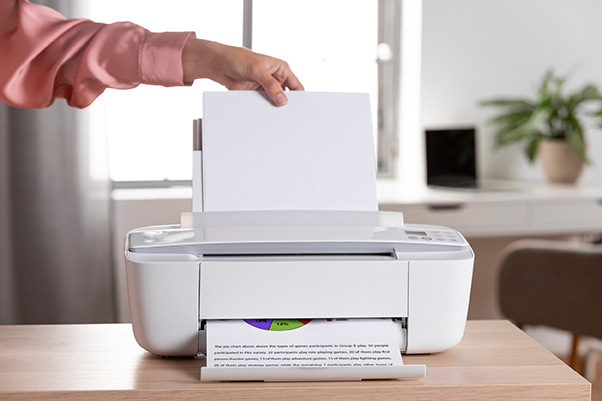 Imprimante blanche posée sur la table d’une maison, imprimant des documents pour le télétravail