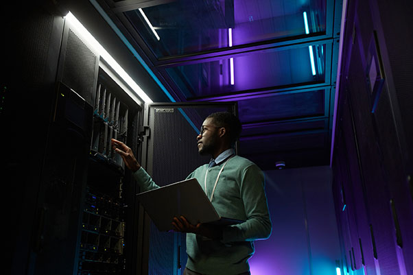 Jeune technicien informatique afro-américain chargé de la gestion de serveurs informatiques