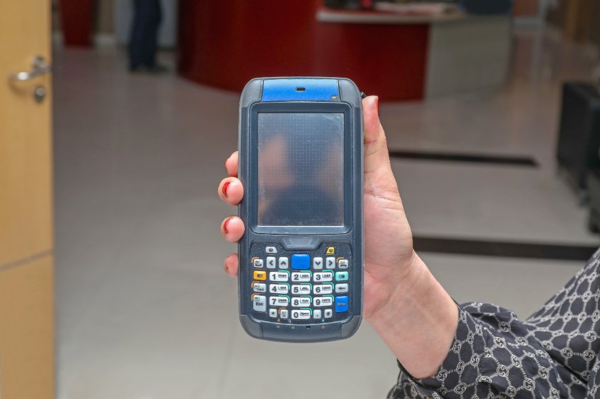 Assistant numérique personnel PDA bleu tenu à la verticale par une main féminine